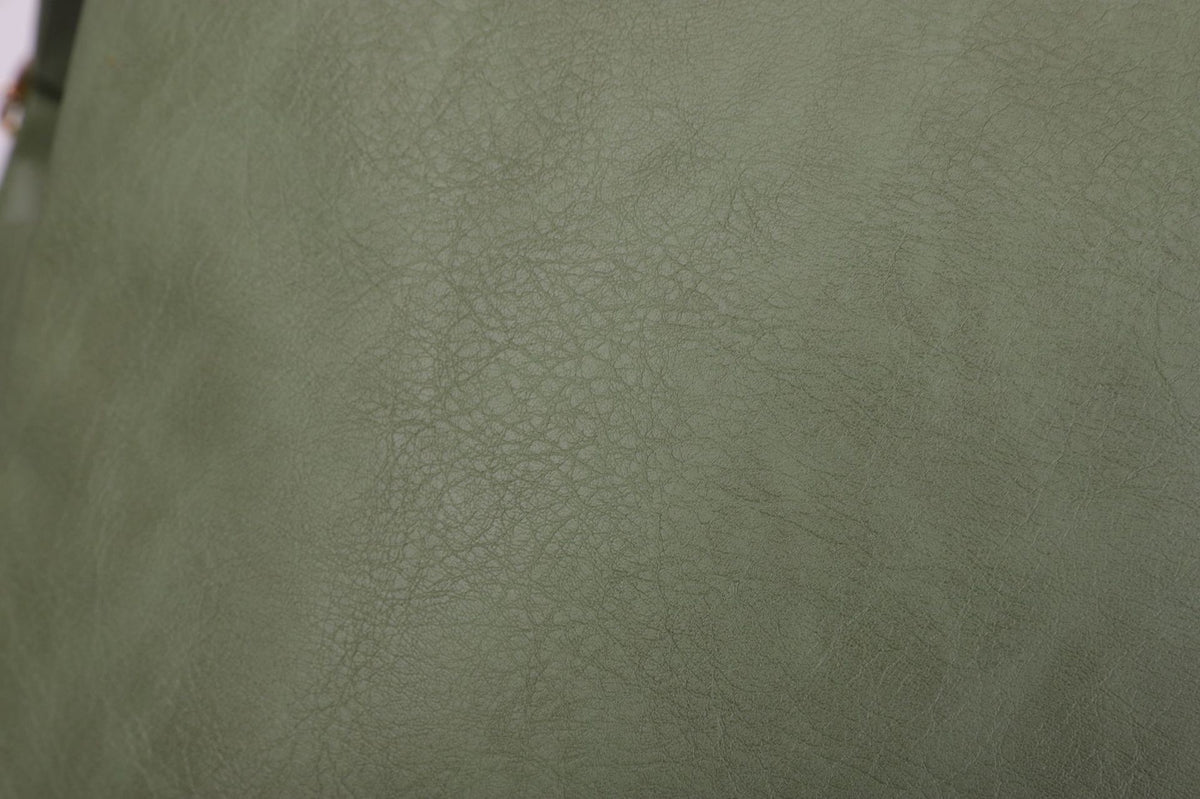close up of green pebbled pu material surface used on the convertible womens backpack
