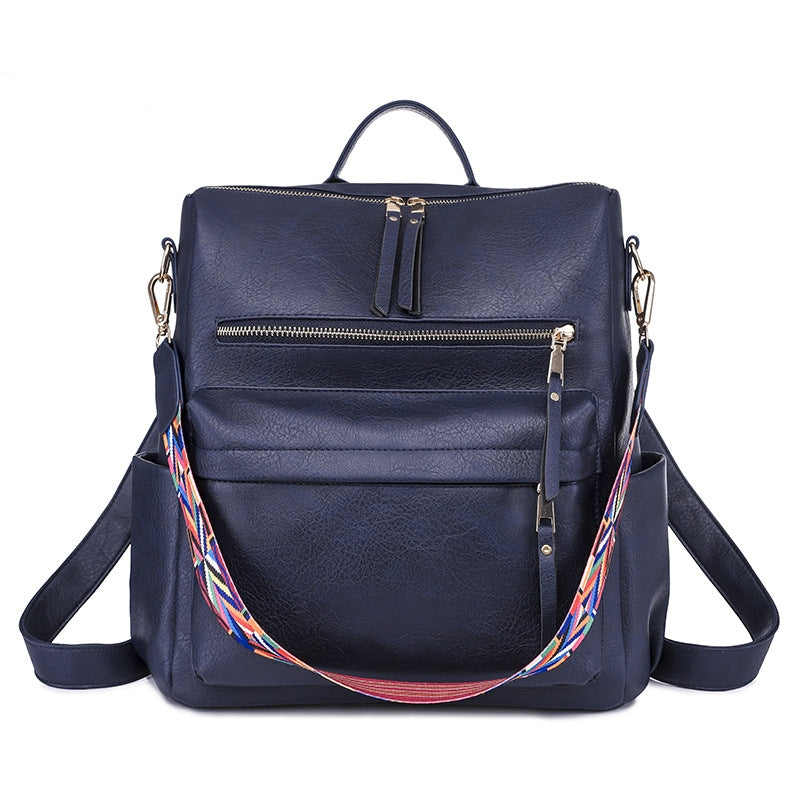 navy womens pu backpack with multiple zipper pockets top handle and colorful woven carry strap