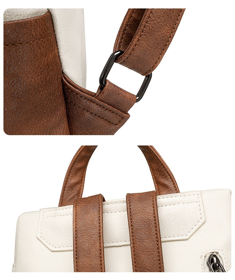close up of brown pu backpack strap attachment reinforced stitching and back handle connection