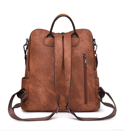 brown convertible backpack rear view with two adjustable straps top carry handle and vertical back zipper pocket