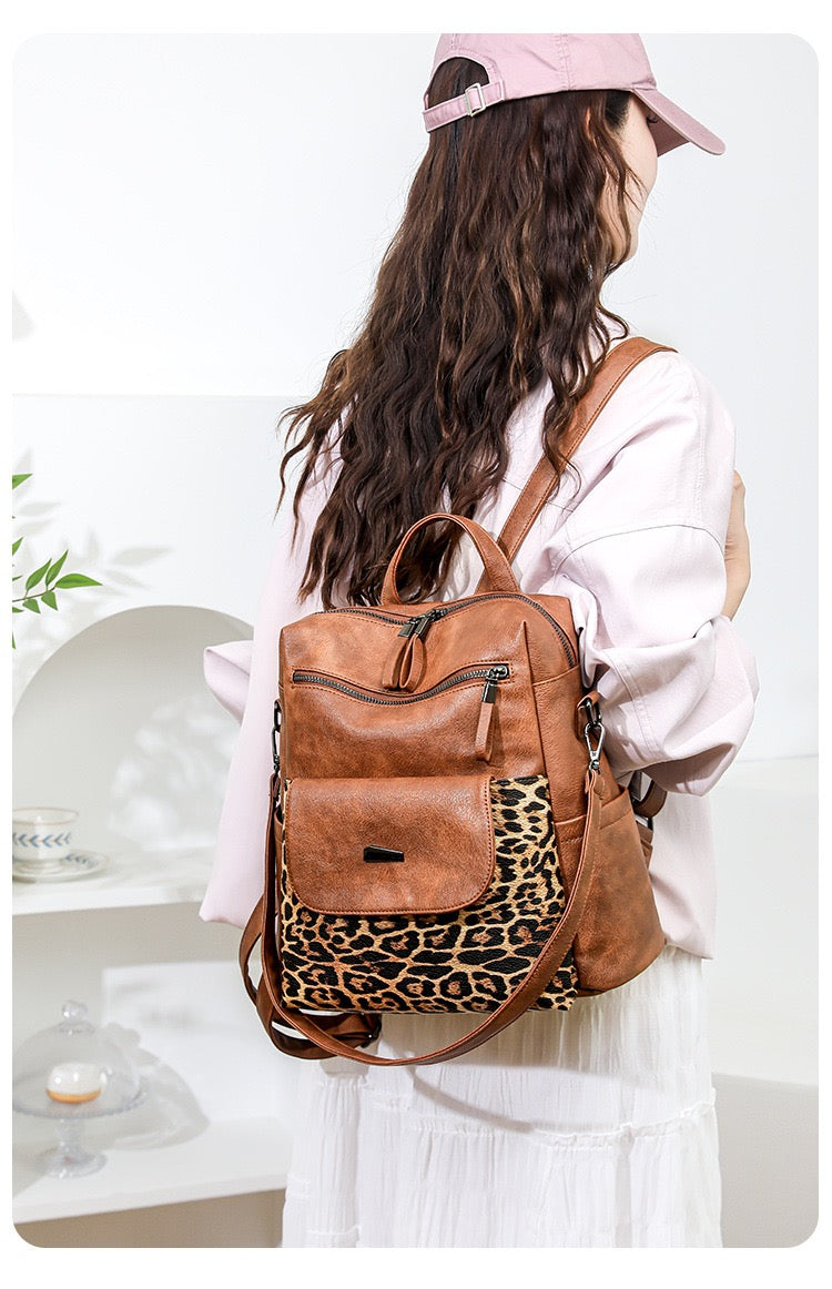 woman wearing brown leopard print convertible backpack with front flap pocket and adjustable shoulder straps