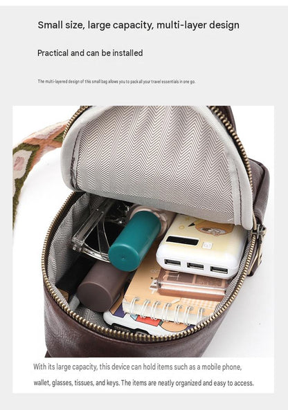 open compact pu sling bag showing lined main compartment with phone power bank notebook and small everyday accessories