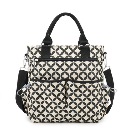 copper coins pattern diaper bag tote with black and white geometric print black top handles side pockets and front organizer