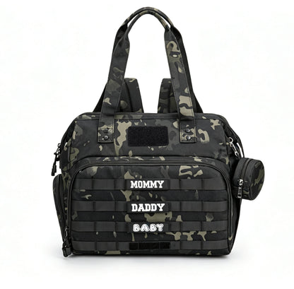 dark camouflage tactical diaper bag tote with top handles patch panels front webbing organizer and round side pouch