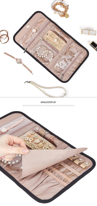 open travel jewelry organizer surrounded by jewelry with a hand lifting the fold-out divider to reveal ring and accessory straps