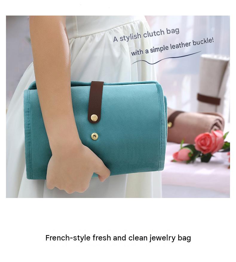 light blue velvet jewelry organizer carried as a compact clutch with brown snap fastening strap