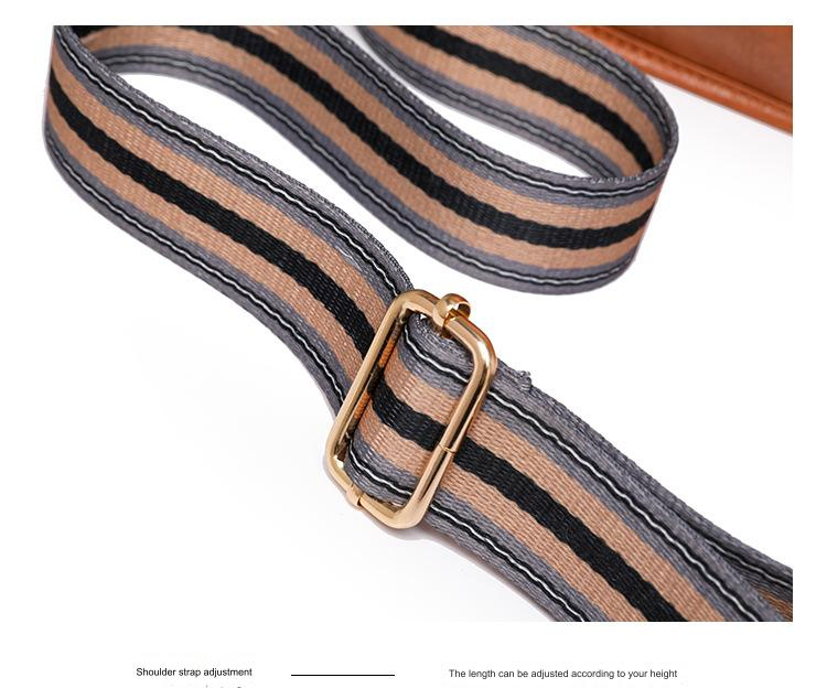 close up of adjustable striped webbing shoulder strap with gold tone metal slider buckle