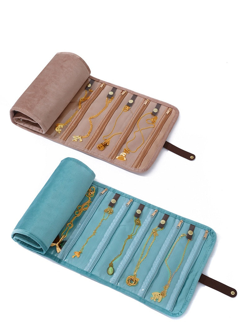 powder brown and light blue roll up jewelry organizers showing soft rolled sections clear zipper pockets and fastening straps
