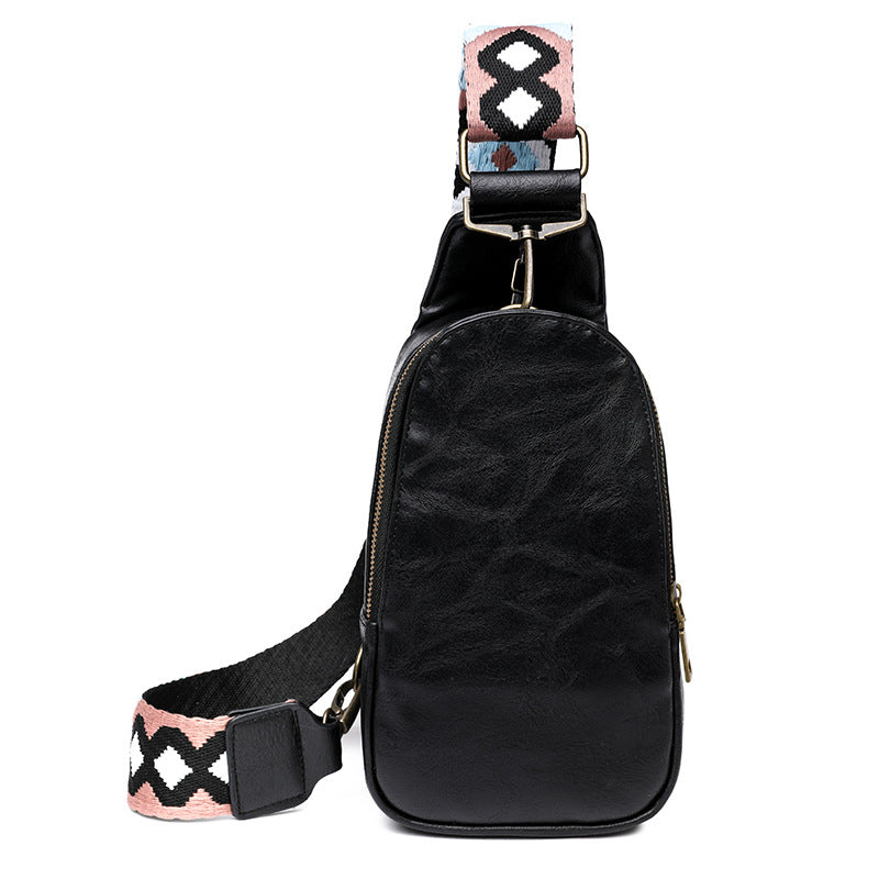 black pu leather crossbody bag with compact curved body front zipper and patterned adjustable shoulder strap