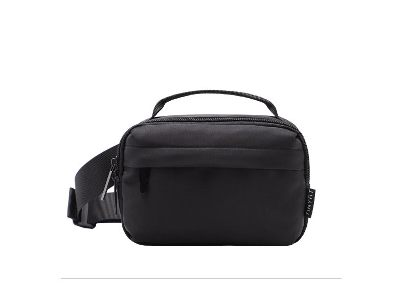 compact black waist pack bag front view showing top fabric handle smooth zipper closure and adjustable waist strap